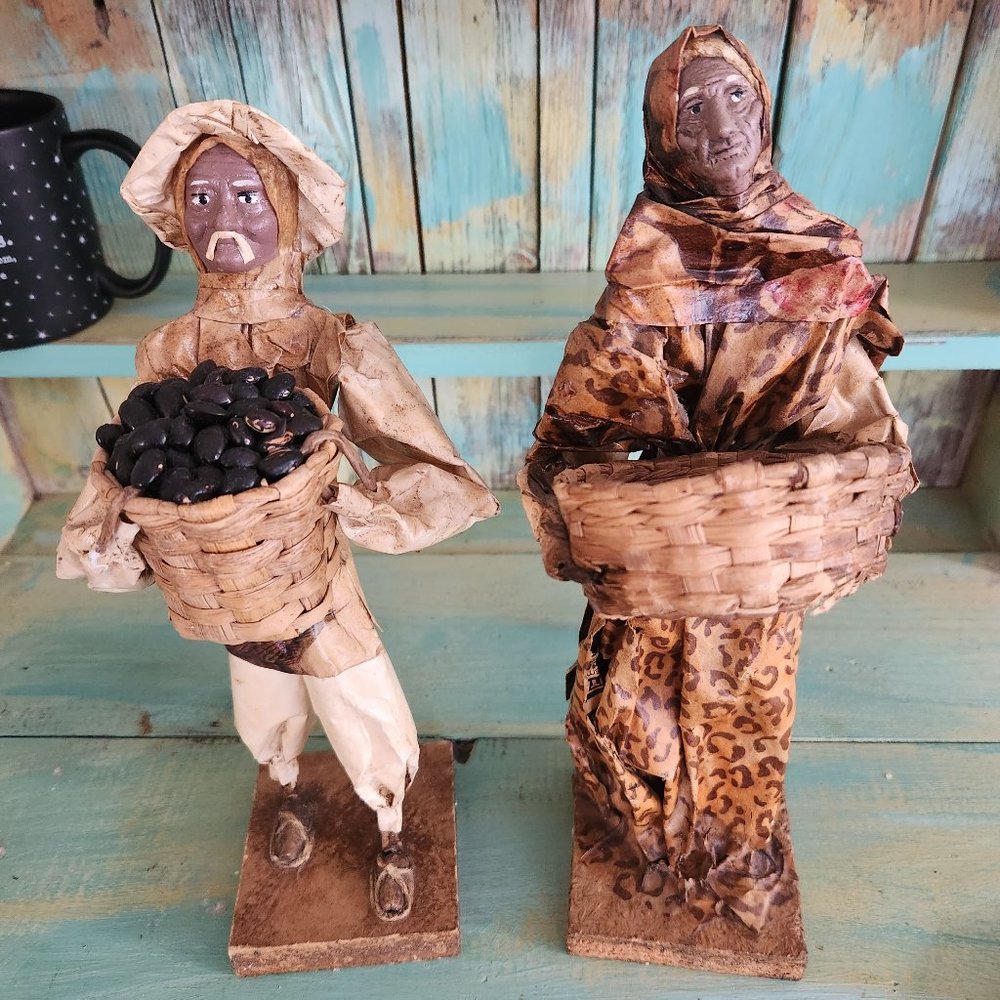 Paper mache figures man holding coffee beans